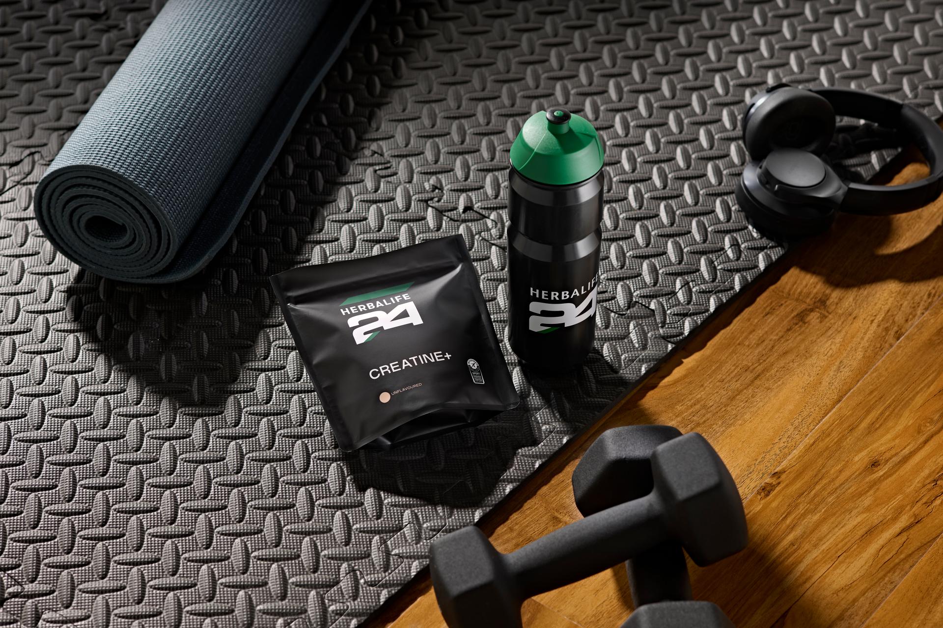 herbalife creatine product on the carpet with other gym sport objects
