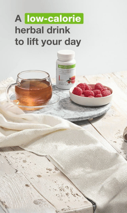 Herbal drink with tea cup, berries, and supplement bottle on a wooden table.